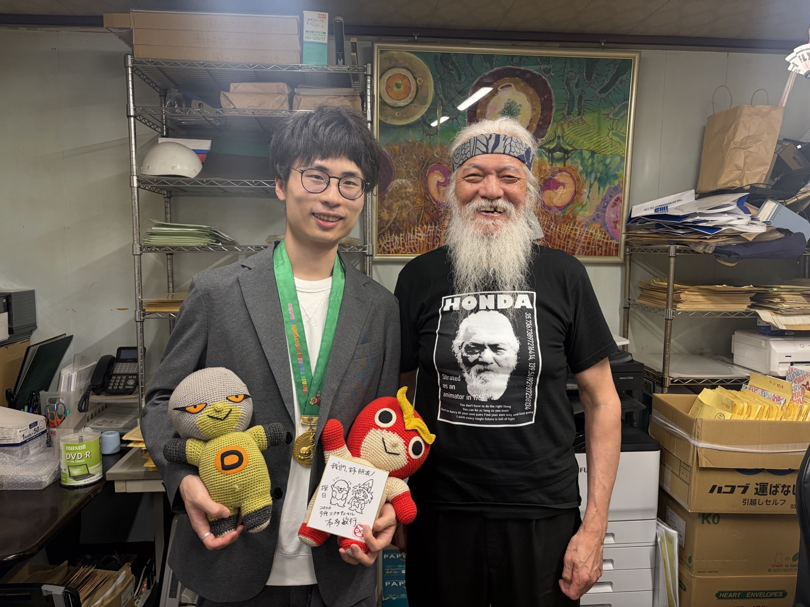 アニメーション監督・本多敏行氏（右）との対談。本多氏に描いていただいた NaviNichi のオリジナルキャラクターとともに。